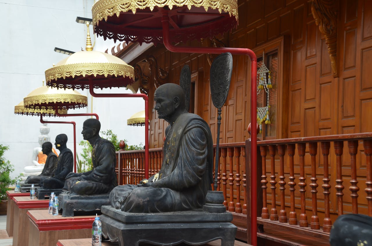 Buddhist statues under ornate canopies, showcasing traditional temple architecture.